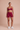 Red athletic outfit with a sports bra and shorts on a beige background