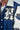Close-up of a blue and white varsity jacket with a prominent 'H' logo.
