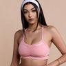 Woman wearing a pink sports bra and leggings set on a beige background